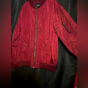 Maroon zip up jacket with inside pockets and zipper pocket on arm.